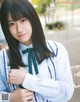 A young woman in a school uniform posing for a picture.