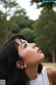 A woman with long black hair looking up at the sky.