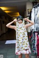 A woman standing in front of a rack of clothes.