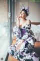 A woman in a kimono sitting on a window sill.