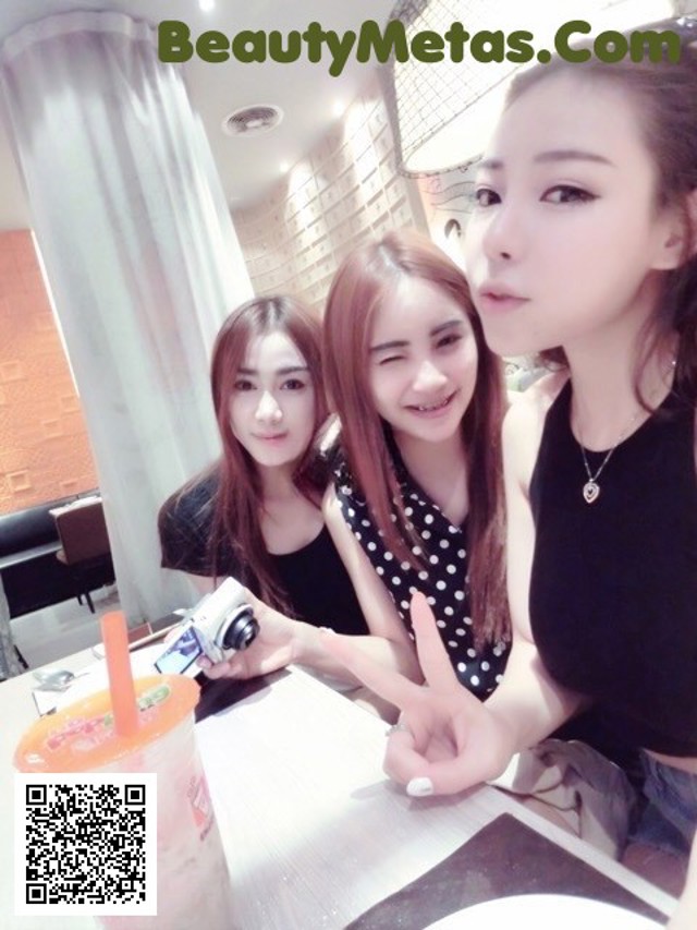 A group of young women sitting at a table with drinks.