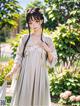 A woman in a white dress standing in a garden.