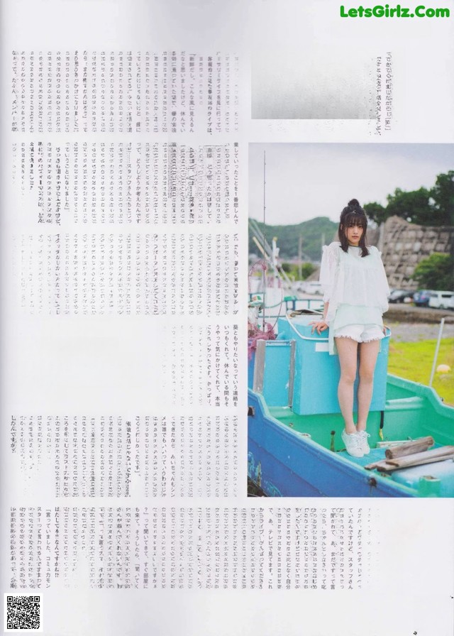 A woman standing on top of a blue boat.